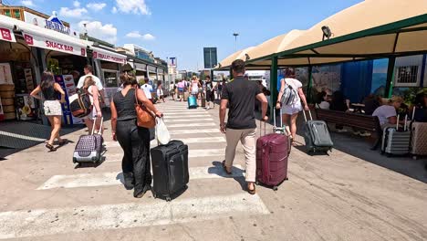 turistas con equipaje caminando a través de un mercado ocupado