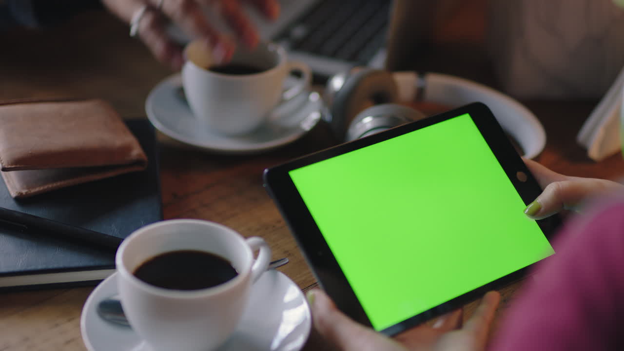 close up donna d'affari mani usando tablet digitale in caffè guardando lo schermo verde sul dispositivo mobile chroma key godendo di intrattenimento online leggere pubblicità sui social media