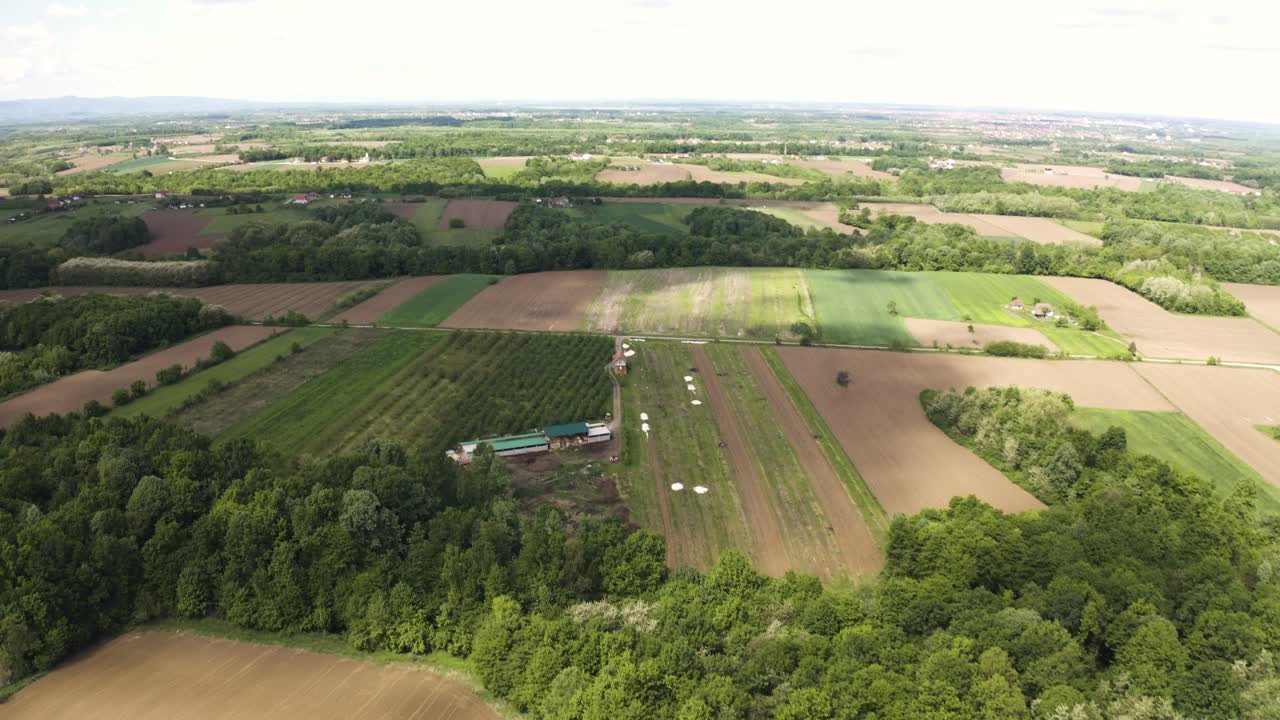 Cinematic drone footage of agricultural field and beautiful flat land in Bosnia and Herzegovina with mountains Majevica in distance