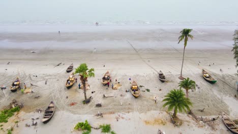 fishing boats with fishermen preparing their fishing nets at kuakata beach in bangladesh