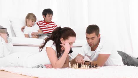 una pareja joven jugando al ajedrez.