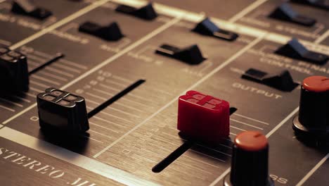 Close-up-of-a-finger-putting-up-the-volume-on-a-stereo-mixer