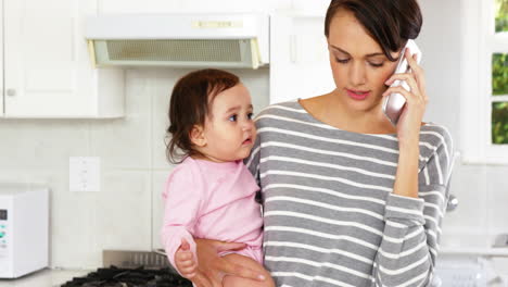 woman calling with her baby in her arms