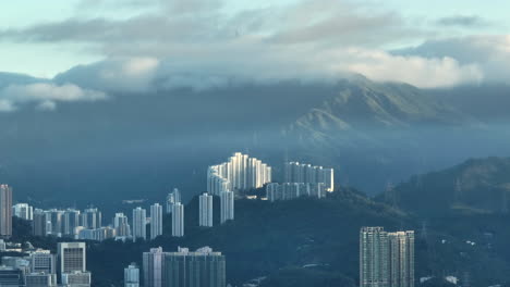 residential high-rise buildings on hill-top with tai mo shan covered in clouds in background