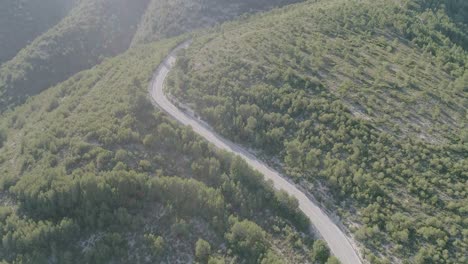 aerial shot of mountain road with lens flare sun effect