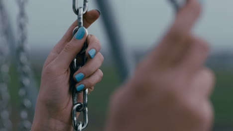 close-up-hands-lonely-woman-on-swing-in-playground-park-swinging-alone-teenage-depression-concept