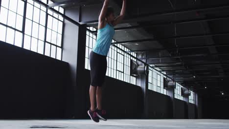 african american woman doing jumping exercises in an empty urban building