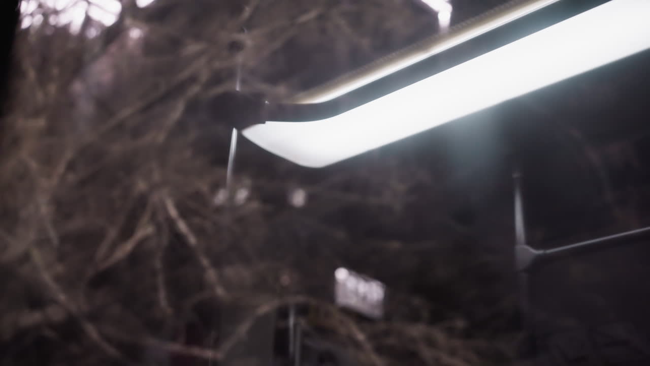 스크린에 빛이 반사되어 어고 흐릿한 배경에 대한 밝은 빛을 포착하는 움직이는 자동차 내부의 가까운 시각