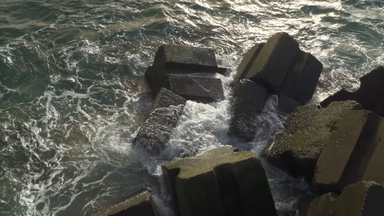 Atlantic Ocean waves crushing into the stone beaches of madeira island, Portugal.