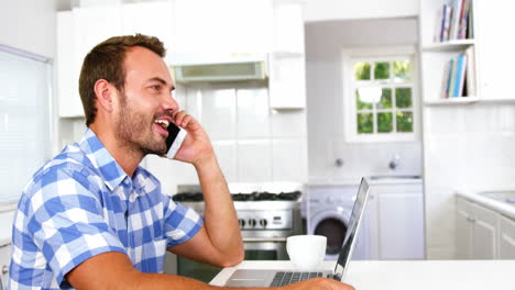 Handsome-man-calling-and-using-laptop