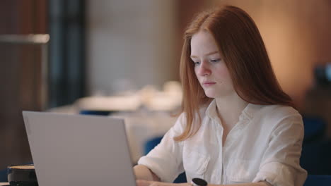 Joven-Profesional-Pelirroja-Escribiendo-Un-Correo-Electrónico-Importante-Desde-Su-Casa.-Salón-Moderno.-Trabajo-Remoto.-Mujer-Seria-Busca-Inspiración-Toma-Decisión-Siente-Falta-De-Ideas