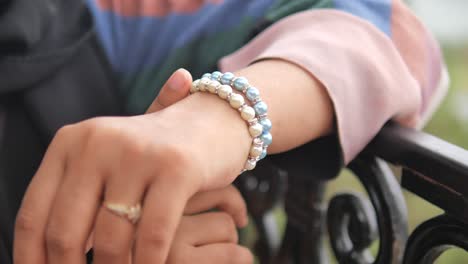 mujer con pulseras de perlas