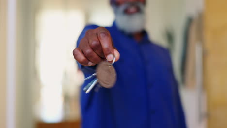 llaves de la casa, manos y primer plano del hombre mayor en nuevo