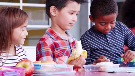 Elementary-school-kids-eating-packed-lunches-at-a-table