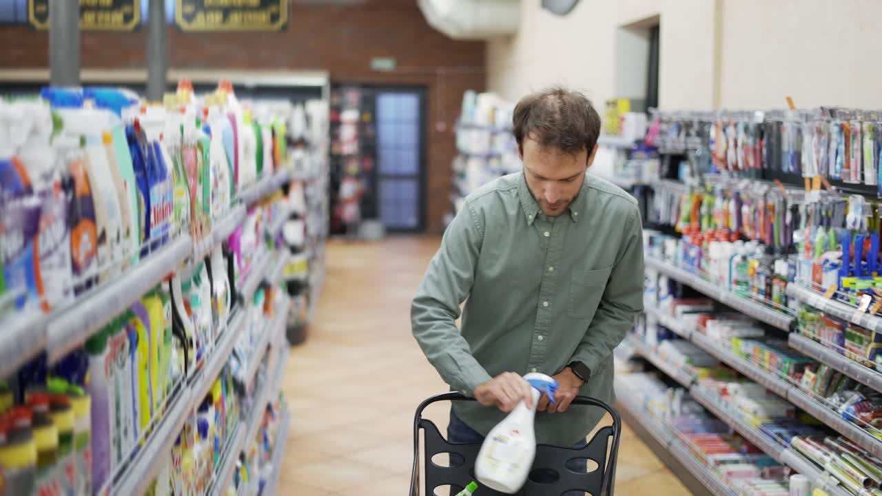 hombre camina por el supermercado y toma las mercancías de la estantería