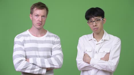 two young multi-ethnic businessmen together with arms crossed