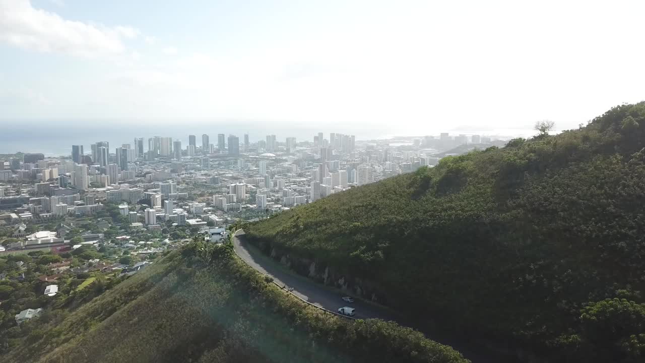 Parking cars on road viewpoint of top of mountain during sunny day. Spectacular view on Waikiki, Honolulu, Hawaii in summer. Aerial wide shot