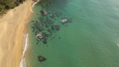 Vista-Aérea-Soleada-Sobre-Playa-Tranquila-En-Costa-Brava,-España,-Agua-Muy-Clara