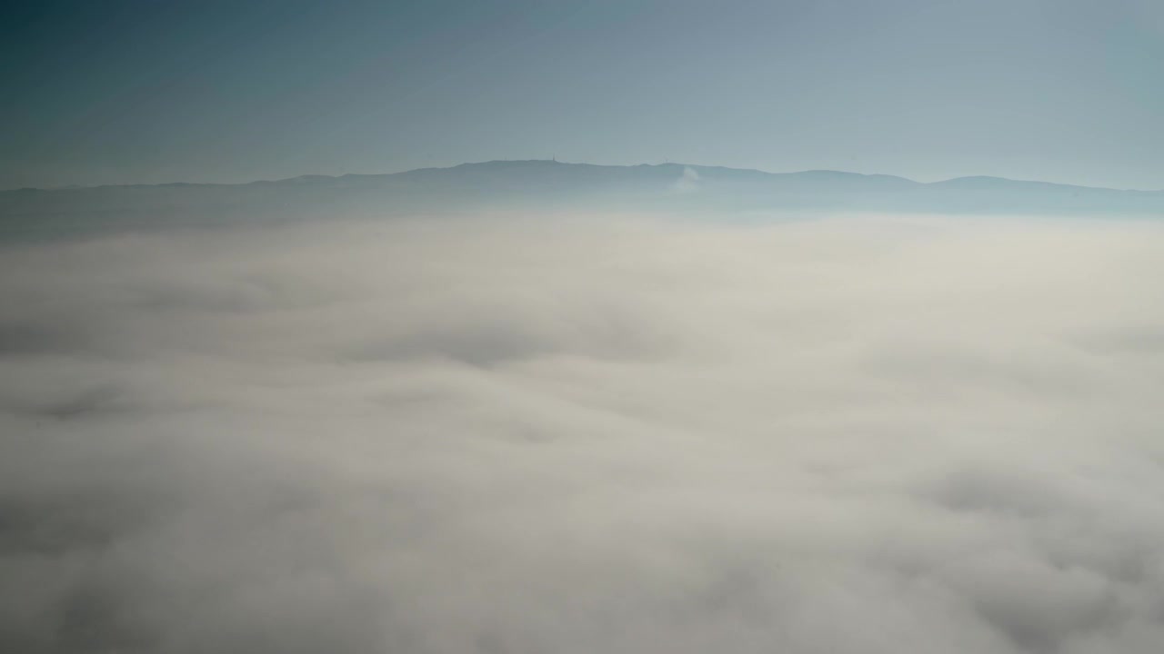 Aerial View of Thick Morning Fog Over Mountain Landscape