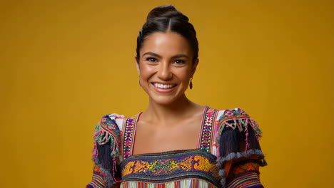 portrait of a smiling woman in colorful traditional attire against a yellow background