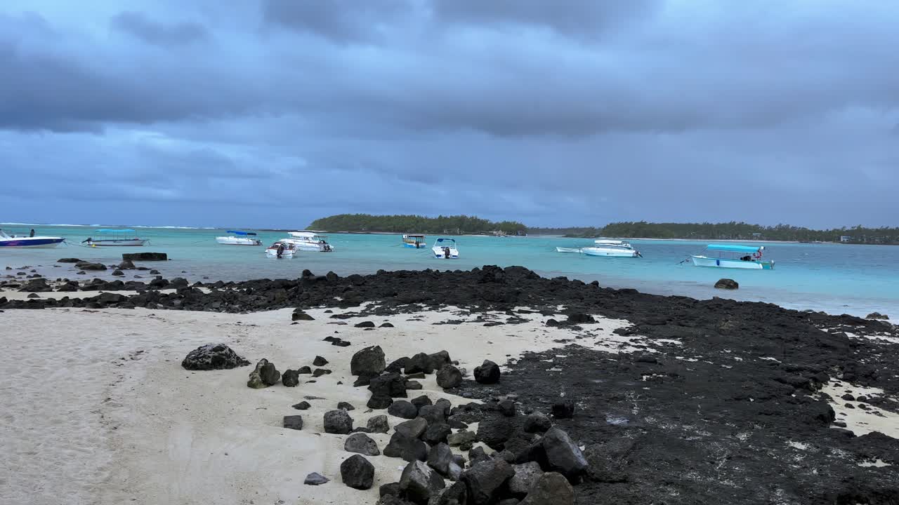 Stormy weather over tropical beach with boats and people