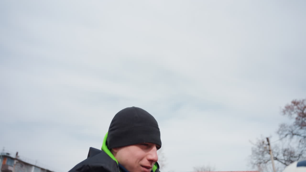 유소년 축구 훈련, 훈련 세션 중 능숙하게 축구를 컨트롤하는 젊은 백인 운동선수, 연습 중 거친 도시 축구장의 골대 옆에서 몸을 푸는 십 대 백인 남성