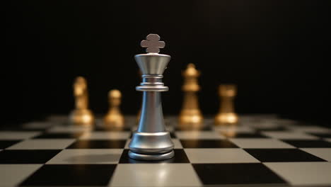 Cinematic-focus-shot-of-chess-pieces-on-a-chess-board,-front-view-of-white-figure-and-other-line-of-yellow-figures-blurred-in-background