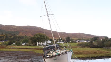 fishing boat on the black sand rocky beach of portree on isle of skye, highlands of scotland