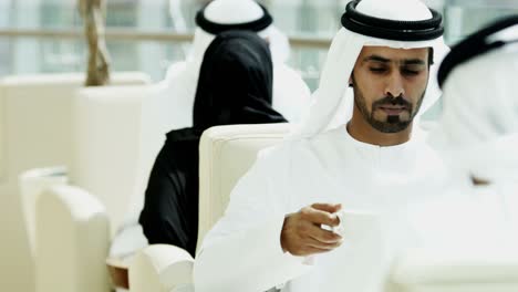 hombres y mujeres ejecutivos de negocios de los emiratos se reúnen usando tabletas