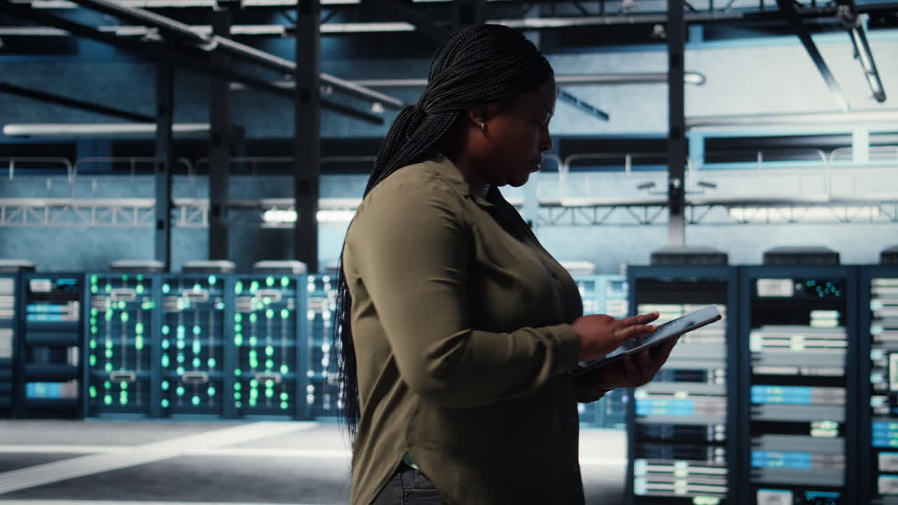 Data center technician monitors data center metrics on tablet