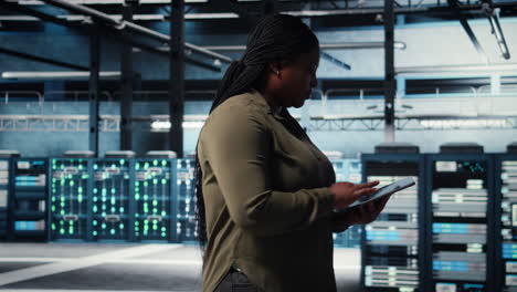 data center technician monitors data center metrics on tablet