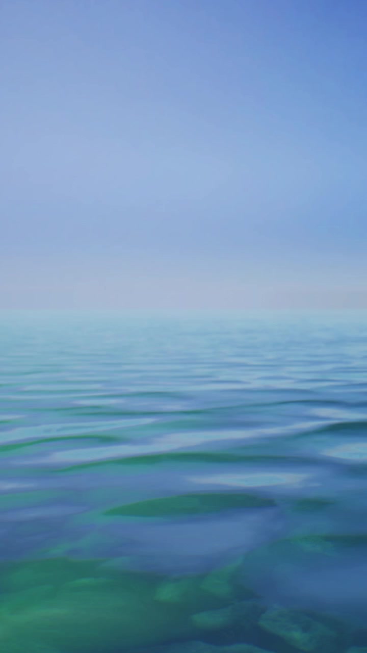 Onde e cielo riflettono la luce durante il giorno su un oceano blu calmo.