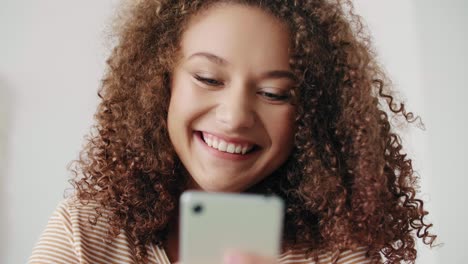 close up of smiling teenage girl with mobile phone