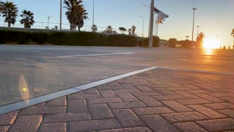 man wearing blue shorts practicing turn on surf skateboard in outdoor park near the beach