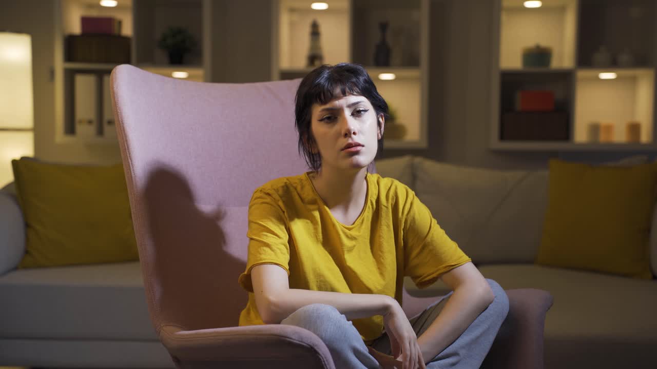 Depressed young woman talking to camera.