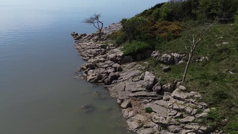 rocky private shoreline aerial view descending to calming dreamlike fantasy bay seascape