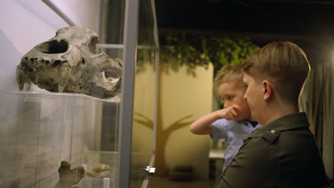 woman and her little son during a natural history museum visit, side view