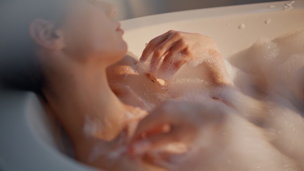 Portrait morning brunette spa procedures. Woman soaking bath filled fluffy foam