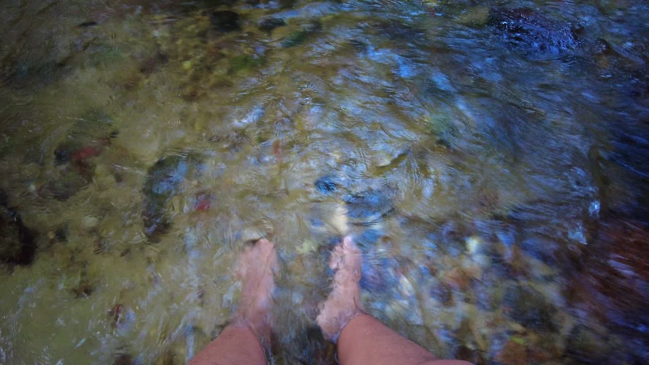 Static view of feet submerged in the Choroni River, in Aragua State, Venezuela, soft light