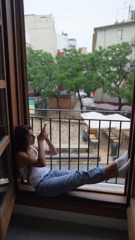 woman relaxing on balcony with city view