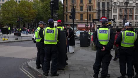 police monitor crowds at trafalgar square near underground exit as people exit tube