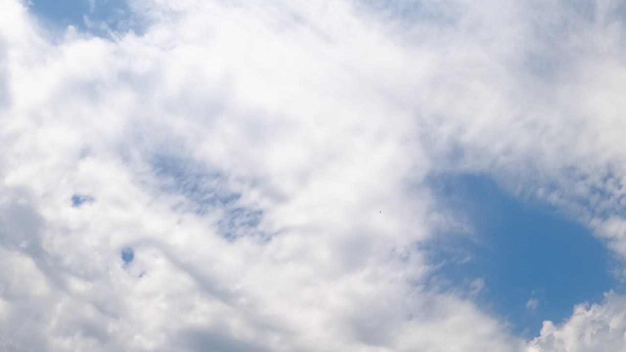 White clouds covering the sky quickly. Blue horizon clears up. Low angle view. Timelapse.