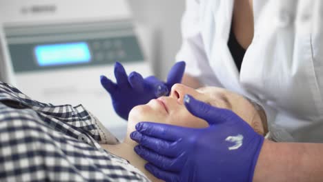 procedimiento de hardware en cosmetología. peeling, fonoforesis, masaje y estiramiento facial en una clínica de belleza. el cosmetólogo suaviza las arrugas con microcorrientes.
