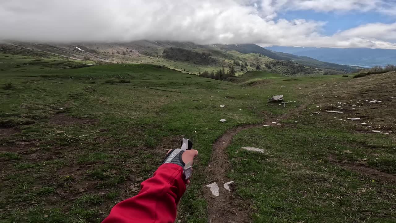 on-board camera, subjective view of a man hiking with poles, in the mountains with a magnificent view of the valley