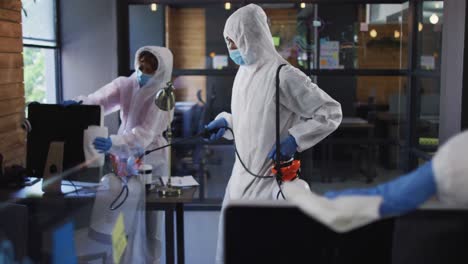 team of health worker wearing protective clothes cleaning office using disinfectant sprayer