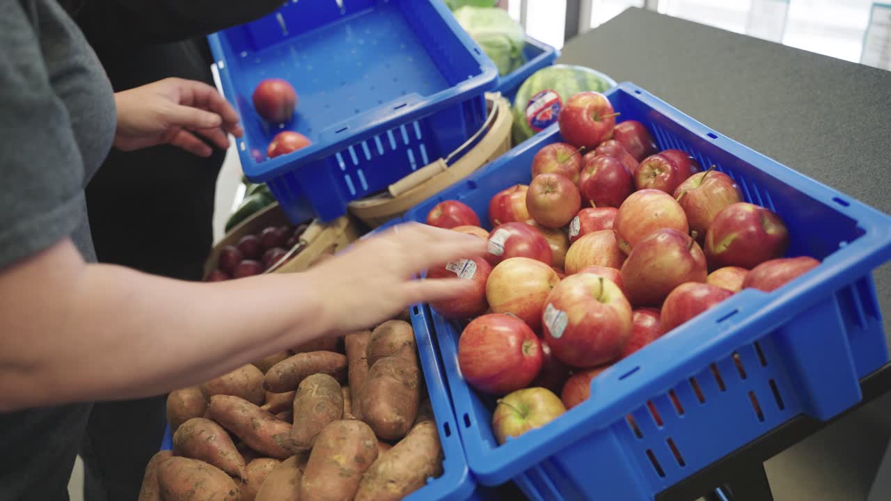 Employees stocking up apples at a grocery store in Minnesota, USA.
