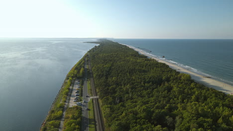 narrow stripe of land with sandy beach and green forest in middle of baltic sea