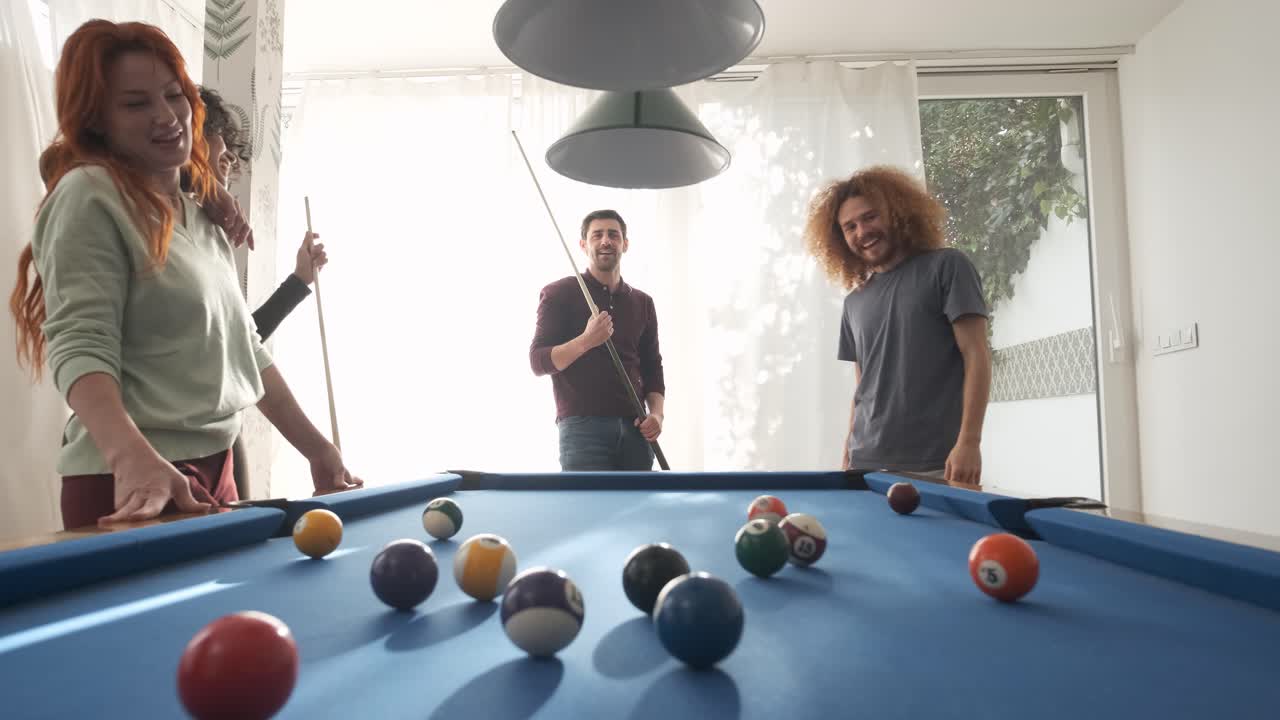 Uomo che gioca a biliardo con amici diversi in sala giochi nel fine settimana