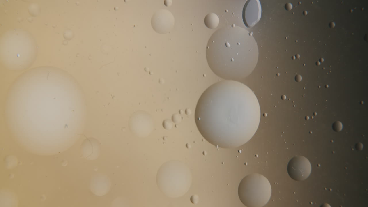 pequeña burbuja de aire transparente que se mueve en un líquido ligeramente dorado