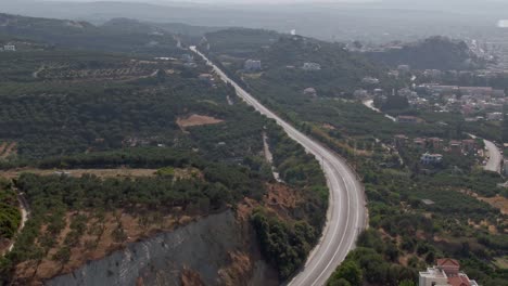 highway road through green and vibrant island of crete, aerial drone view